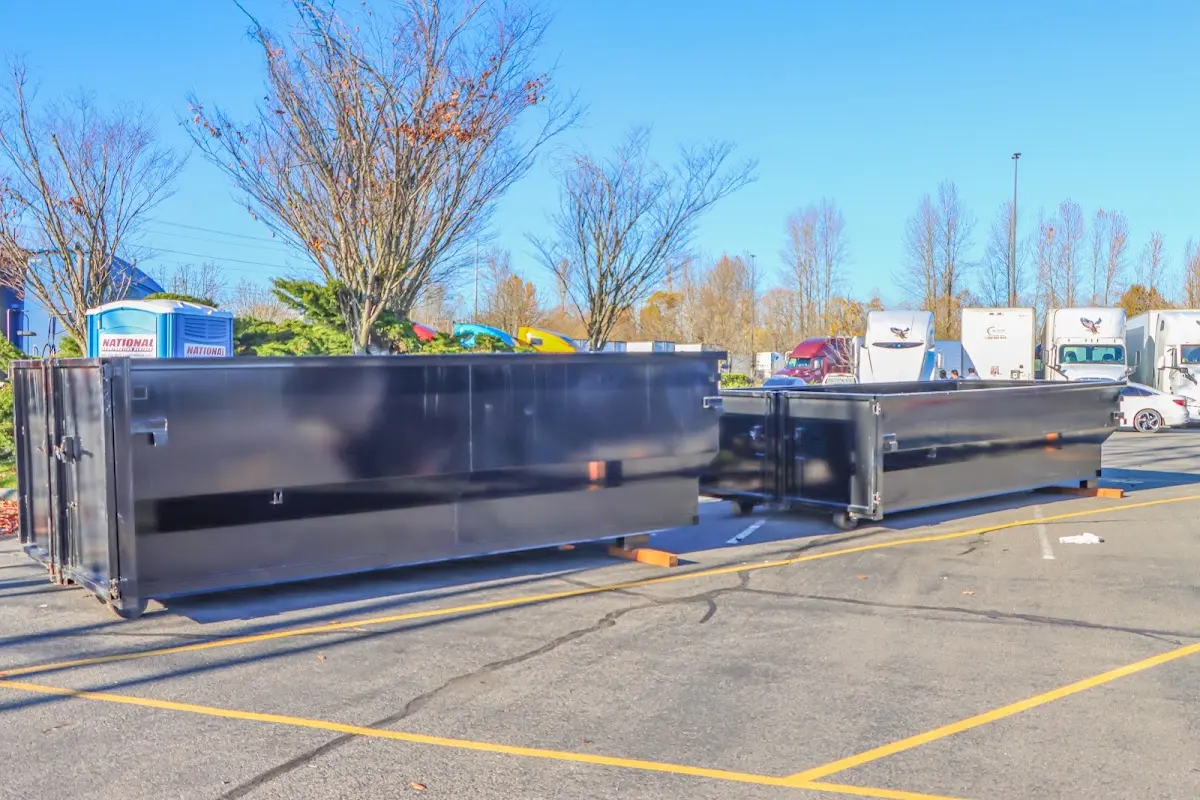 Professional dumpster rental service with roll-off container on residential driveway in San Benito